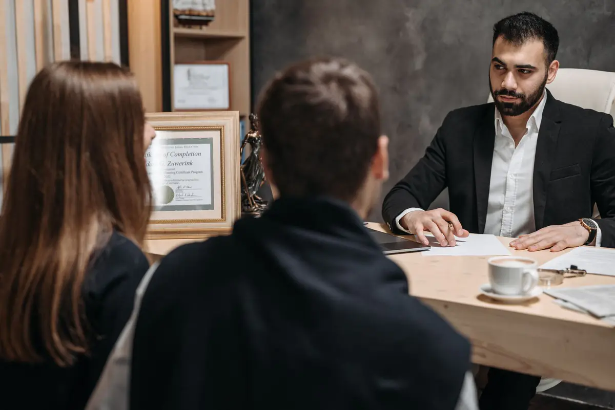 A lawyer at his desk talking with two clients